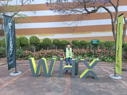 Staff standing in front of large WHX letters at the exhibition entrance